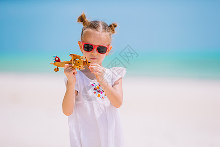 在海滩上玩玩具飞机的快乐女孩儿 梦想成为飞行员的小孩啊! 未来 旅行图片