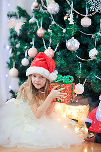 在圣诞树附近的可爱的小女孩 圣诞树下的孩子们带着礼品盒 笑 季节图片