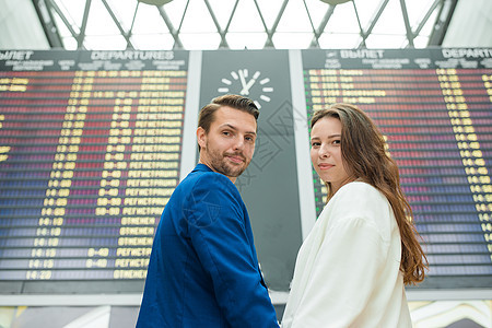 国际机场的年轻夫妇在看飞行信息板时观看飞行信息板 假期 旅行图片