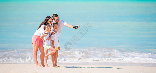 男人在海滩上拍家人照片时 幸福 母亲 拥抱 摄影图片