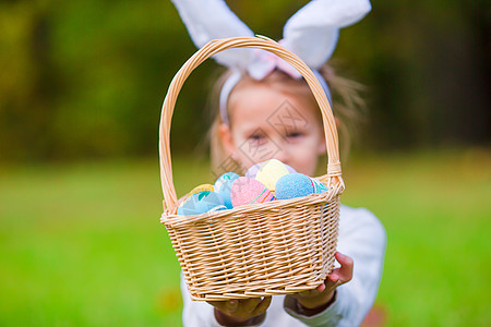 穿着兔子耳朵的可爱小女孩 在春日户外带了一篮充满复活节鸡蛋的篮子 孩子 喜悦图片
