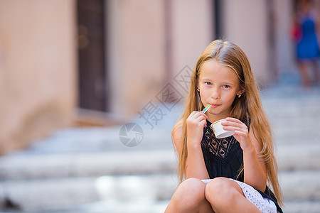 城市夏季在户外吃冰淇淋的可爱女孩图片
