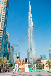 一家人快乐地在迪拜走来走去 背景中还有摩天大楼 家庭 城市图片