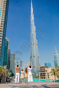 一家人快乐地在迪拜走来走去 背景中还有摩天大楼 建筑 水图片