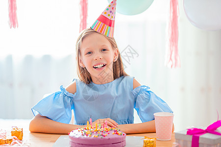 白种女孩梦寐以求地笑着看生日彩虹蛋糕 喜悦的多彩背景与气球 生日派对和祝愿概念 展示 食物图片