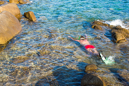 年轻男子在热带绿绿水中潜伏 游泳 游泳衣 比基尼图片