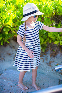 热带沙滩度假期间可爱的小女孩; 闲暇 手提箱 海景图片