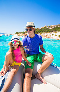 年轻父亲和可爱的女孩 在一条大船上休息 游泳图片