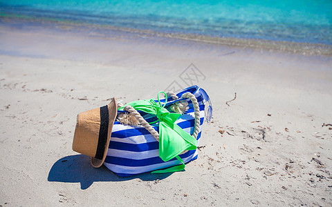 白色热带海滩上的条纹袋 草帽 防晒霜和毛巾 太阳 旅行图片