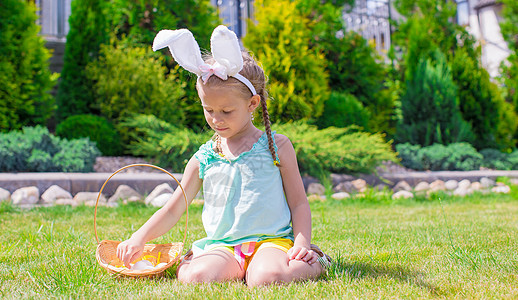 穿着兔子耳朵 拿着复活节鸡蛋篮子的可爱小女孩 假期 传统图片
