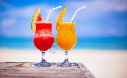两杯鸡尾酒新鲜西瓜和芒果 以惊人的松绿海为背景 杯子 假期图片