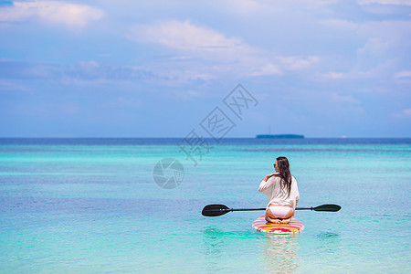 参加运动的青年女子 在掌板上起立 冲浪 夏天图片