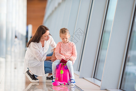 在机场等待飞行的有登机证的母亲和小女孩 母亲和少女 学步的儿童 室内的图片