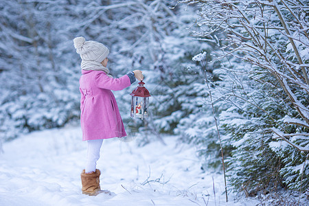 在冬季森林户外带手电筒的可爱小女孩 圣诞节在冬林 蜡烛 路图片
