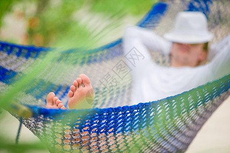 年轻人在稀奇热带度假的吊床上放松图片