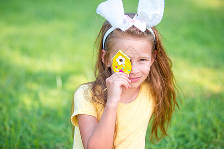穿着兔子耳朵和复活节鸡蛋玩耍的可爱小女孩图片