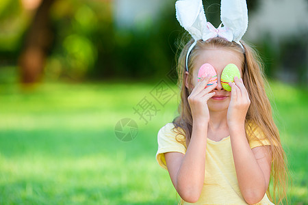 春日穿兔子耳朵和复活节鸡蛋的可爱小姑娘 快乐的图片