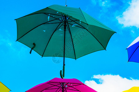 五颜六色的雨伞城市街道装饰 挂着七彩的你 庆祝 蓝色的背景图片
