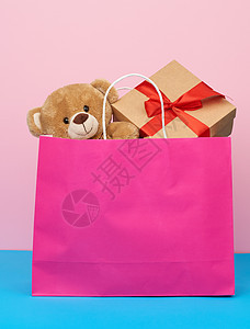 带礼物和泰迪熊的粉红色纸袋 购物概念图片