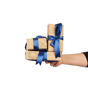手手里握着一堆包装的礼物 在棕色手纸上 圣诞节图片
