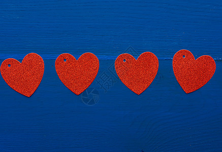 深蓝色木质背景上的纸红色闪亮装饰心 假期 情人节图片