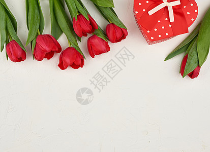 红色盛开的郁金香花束 配有绿色叶子和礼物图片