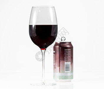 酒杯中的红葡萄酒 配有单装饰品的铝制品背景图片