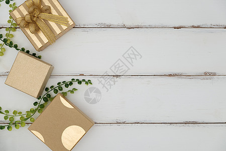 在白色木背景的礼物盒与绿草图片