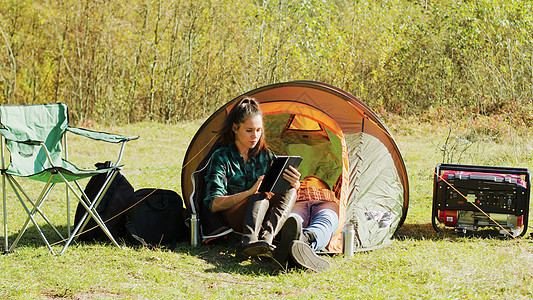 美丽的年轻女友在露营帐篷前使用平板石牌 生活图片