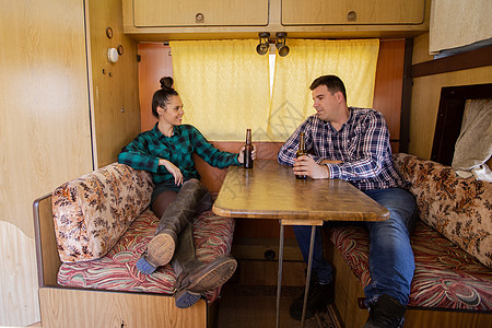 坐在露营车桌边的年轻夫妇 在谈论一些东西图片