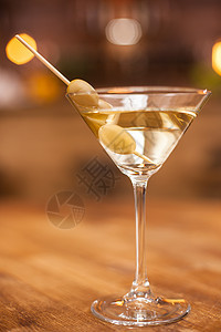 关闭马提尼酒杯 将橄榄放在木桌上的再生润滑剂上 寒冷的 餐厅图片