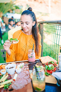 希腊圣托里尼美丽的女人在咖啡室吃早餐 在辛克特尔的风景令人惊叹 喝 镇背景