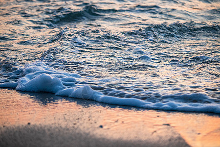 日落时在海滩的海浪中 日出 海岸线 岛 反射图片