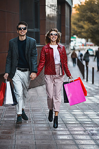 一对在街上随便买东西的情侣前视线向拿着多彩购物袋的照相机跑来 浪漫 女士图片