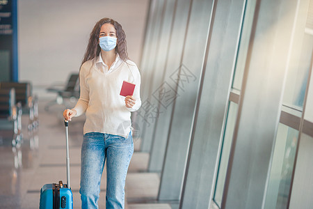 在国际机场提着行李的年轻女子 航空公司乘客在机场休息室等待飞行飞机 护照 药品背景