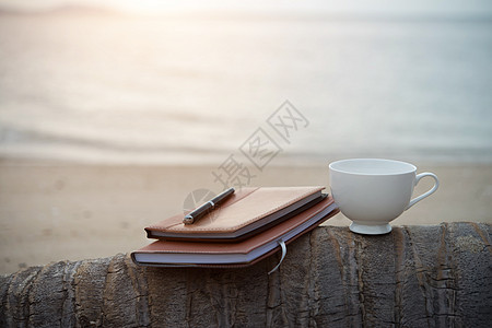 海滩上的笔记本 bookspen 和一杯咖啡图片
