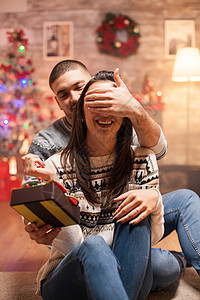 眼罩着微笑的女友 冬天 树 毛衣 幸福 圣诞节 礼物图片