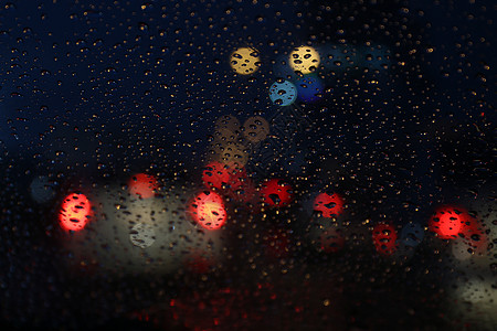 夜生活背景散景和玻璃上的雨滴模糊散景照明多彩 星星 城市图片