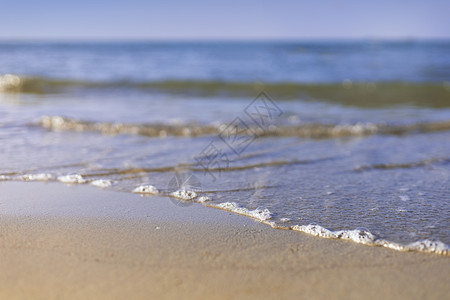 海中柔软的海浪来到湿沙滩 天空模糊 假期 海滩图片