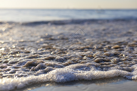 海中柔软的海浪来到湿沙滩 天空模糊 夏天 岛图片