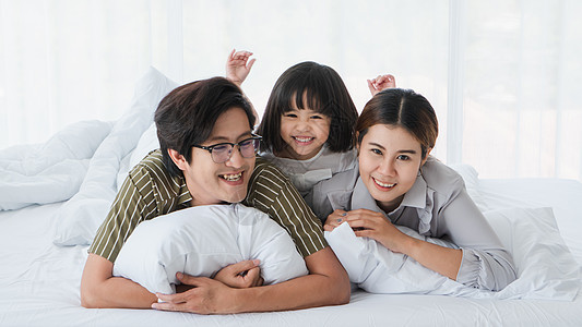 父母和孩子在卧室里玩耍 爸爸 妈妈 微笑 阅读 活动图片