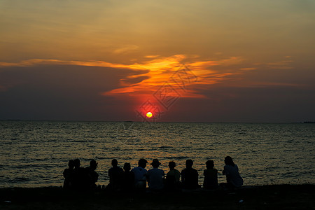 秋后家人在沙滩上看着日落的天空 跳跃 庆典 美丽图片