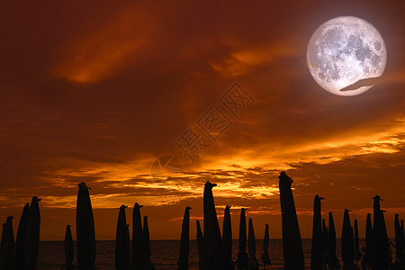 满月在天空 日落和海滩雨伞的阴影下 寺庙 户外图片