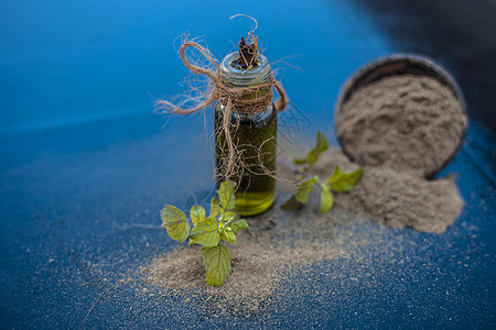 Ayurvedic 草药brahmi或Waterhyssop油 装在一个小型透明玻璃瓶中 连同木质表面的粉末 树 药品图片