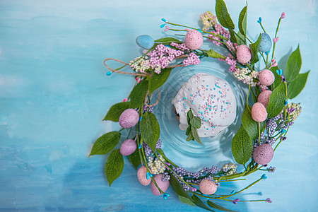 蓝色复古背景中春花花环中心的复活节蛋糕 有复制空间 假期 奶油图片