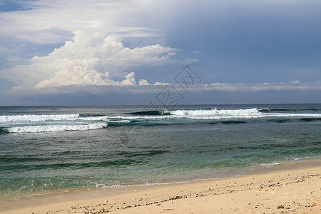巴厘岛上的处女海滩 细黄沙 孤独的热带天堂 拥有海滩 湛蓝的天空 阳光灿烂的日子 汹涌的海浪成排地逼近岸边 滚滚波浪中的海浪 泰图片