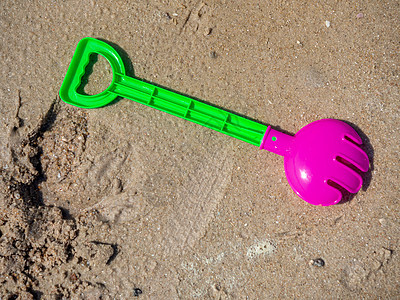 沙地背景的多彩儿童海滩玩具 铲 塑料 假期 蓝色的图片