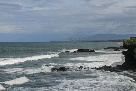 巴厘岛海岸附近印度洋的岩石悬崖 靠近和旅游景点海神庙 波浪在凝固的黑色火山熔岩的岩石上破碎 印度尼西亚 罗兹 旅行图片