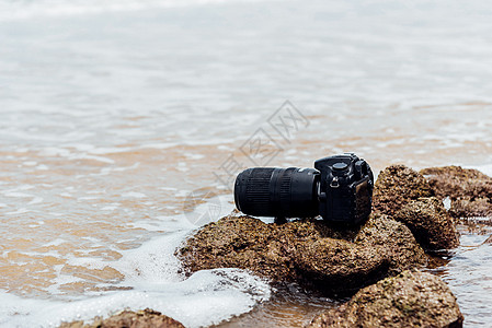 DSLR 在海浪下浸湿的石沙滩上的德国航天中心照相机 单反 远程图片