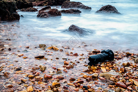 DSLR 在海浪下浸湿的石沙滩上的德国航天中心照相机 沉浸 电子产品图片